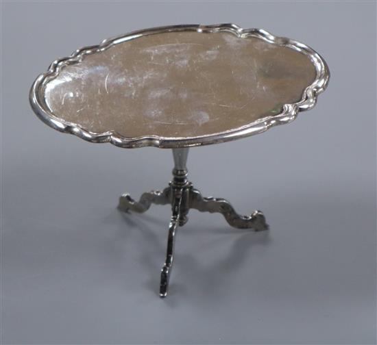 A Dutch 19th century miniature white metal tilt-top table, the oval top with piecrust edge, height 69mm.